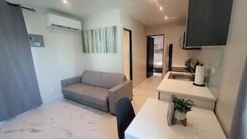 Apartamento, 1 cama Queen e sofá-cama | Área de estar | TV de tela plana 40 polegadas com canais digitais, serviços de streaming