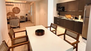 Una cocina moderna con armarios oscuros, un refrigerador de acero inoxidable y un microondas.