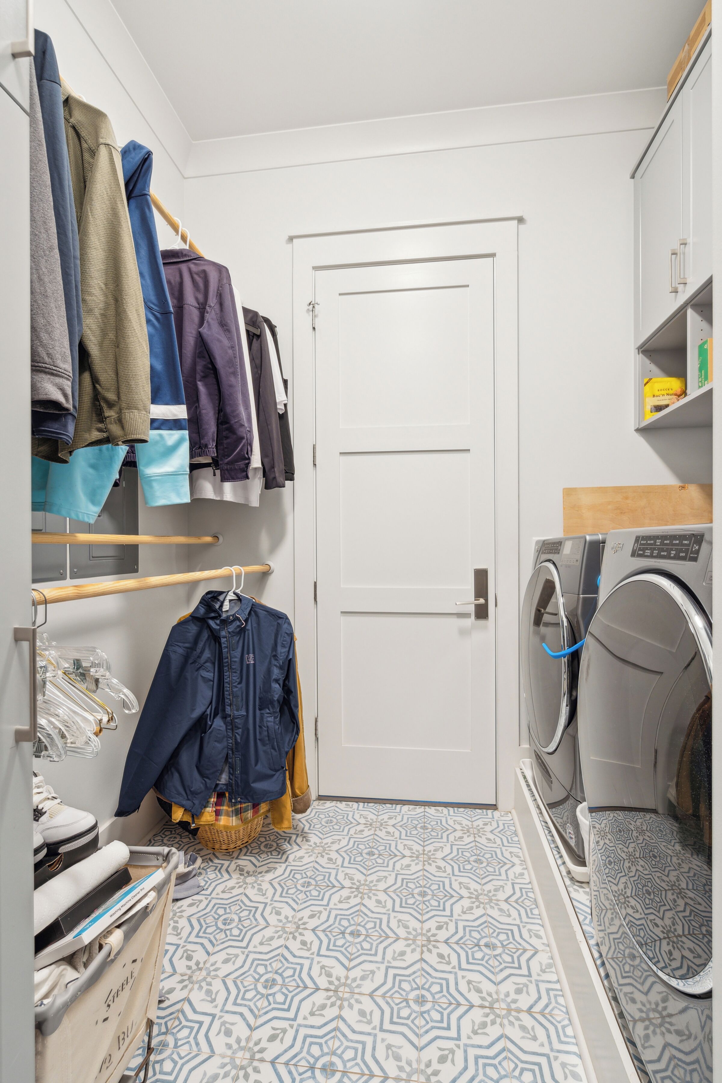 A laundry room with a washing machine, a drying rack, and a door.