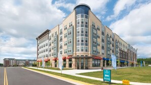 A multi-story building with a curved corner, large windows, and a flat roof. - National at Woodbridge (Woodbridge)