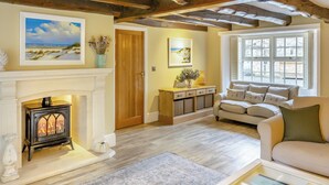 A cozy living room with a fireplace, a sofa, a coffee table, and a window with a view. - Steelclose House - UK48471 (Lintzford, near Rowlands Gill)