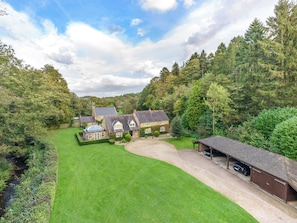 A large estate with multiple buildings, a covered carport, and a well-maintained lawn.