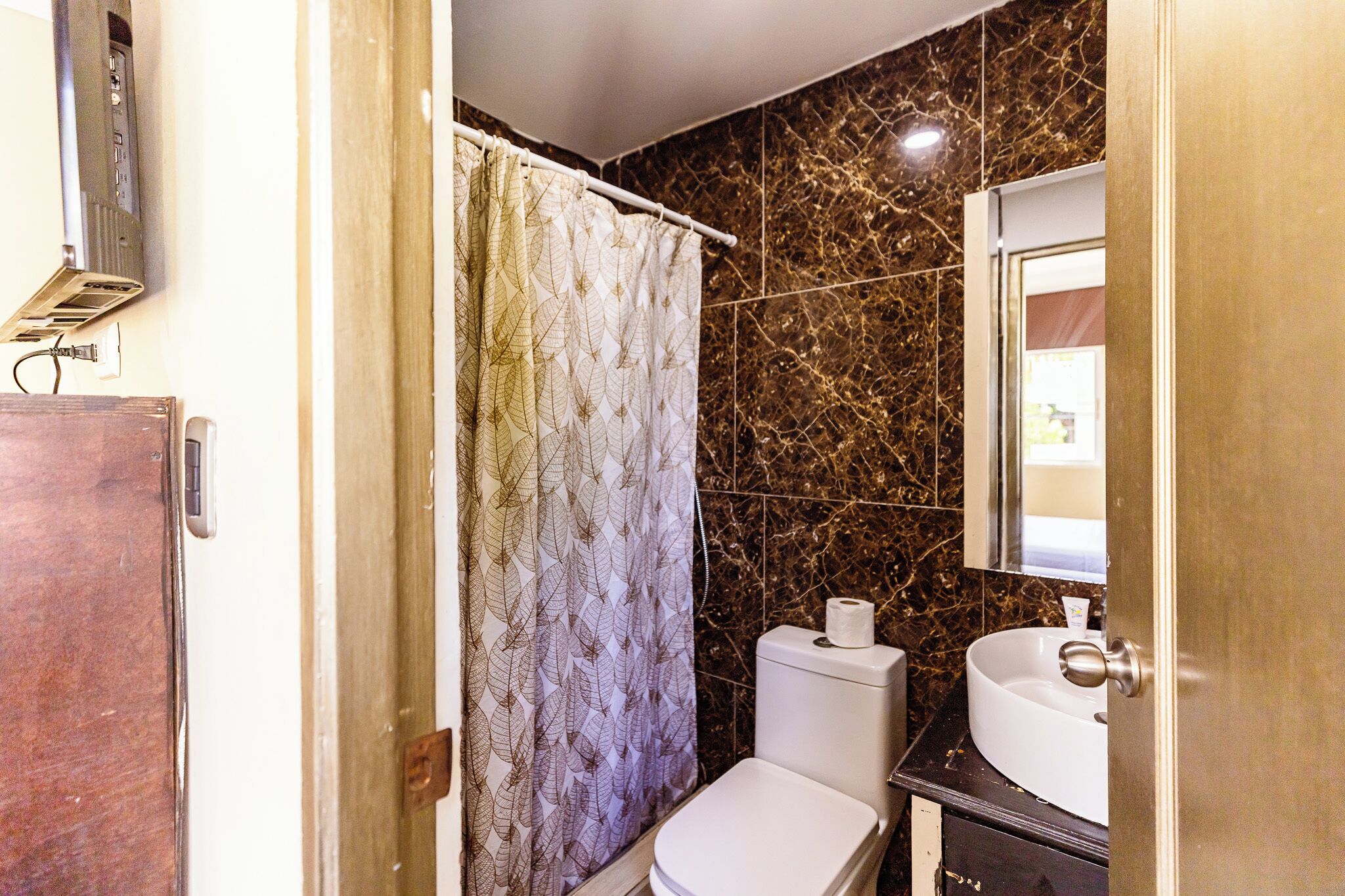 Un baño con inodoro, lavamanos y cortina de ducha.