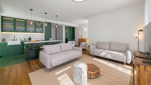 Uma sala de estar moderna com sofá, banquinho e mesa de centro.