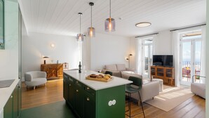 Cozinha moderna com uma ilha verde, armários de madeira e iluminação pendente.