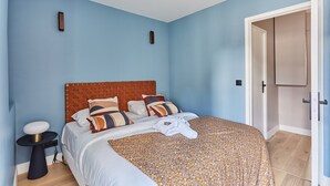 A bedroom with a bed, a bedside table, a wardrobe, and a door. - Magnificent new Flat Le Marais/beaubourg (Paris)