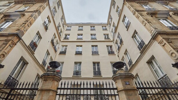 A corner building with a symmetrical facade, multiple windows, and a black wrought iron fence. - Apartment in the Center of Paris/montmartre (Paris)