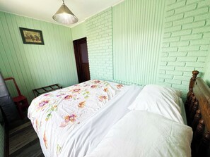 A room with a bed, a wooden headboard, a hanging light fixture, and a door. - Greenfield Gem, 2026 MAJOR UPGRADES! (Pittsburgh)