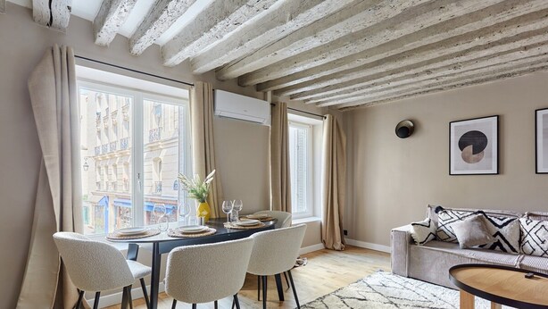 A dining area with a table set for four, a sofa, and a coffee table. - Charming new Flat Le Marais/beaubourg (Paris)