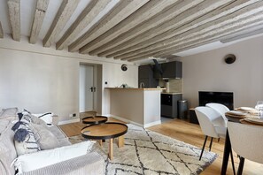 Ein modernes Wohnzimmer mit Sofa, Couchtisch und Essbereich.