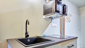 Une cuisine moderne dotée d’un évier encastré, d’un four à micro-ondes et d’un petit plan de travail.