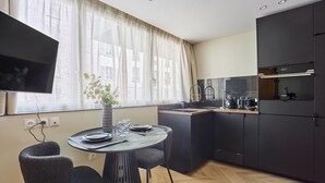 Una cucina moderna con zona pranzo, televisione a schermo piatto e una pianta in vaso.