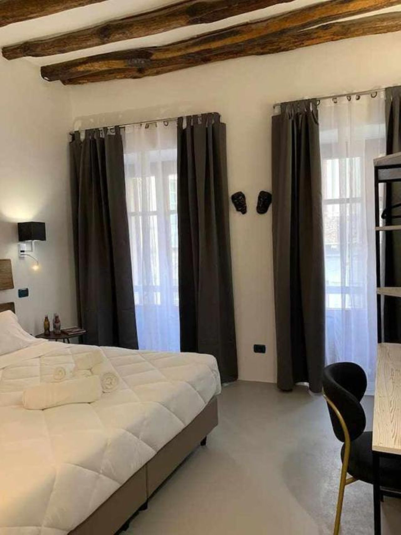 Une chambre à coucher avec un lit, une table de chevet, une chaise et une bibliothèque.
