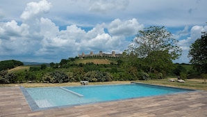 Ein Swimmingpool mit Blick auf eine Burg auf einem Hügel.