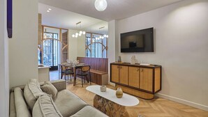 Ein modernes Wohnzimmer mit einer Couch, einem Couchtisch und einem an der Wand befestigten Fernseher.