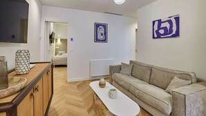 Ein modernes Wohnzimmer mit einer Couch, einem Couchtisch und einem an der Wand montierten Fernseher.
