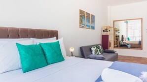 A hotel room with a bed, a sofa, a mirror, and artwork on the wall. - Pi502 Zona4 in Rio de Janeiro (Rio de Janeiro)