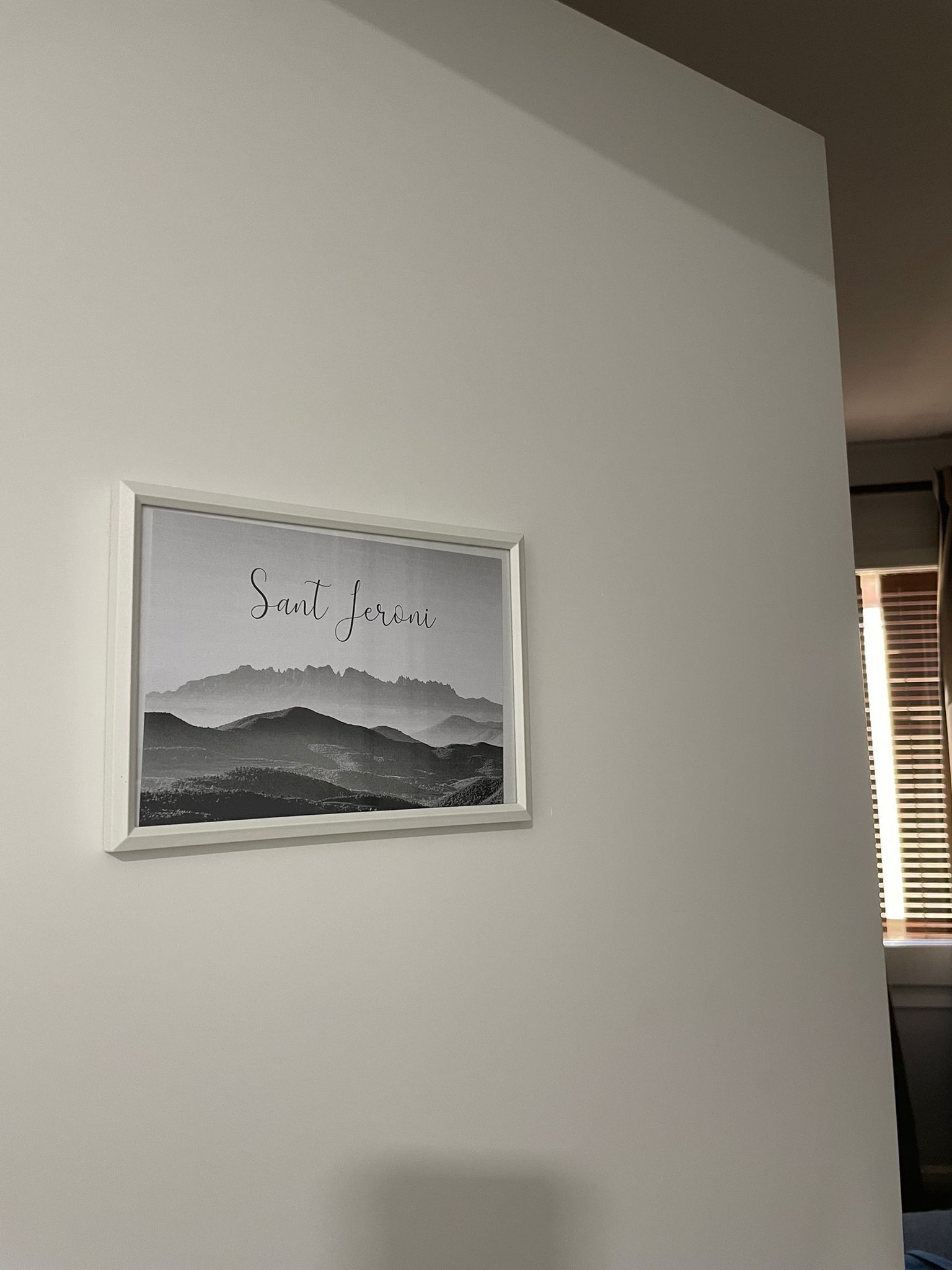 Une photographie en noir et blanc, encadrée, représentant un paysage montagneux, avec l’inscription « Sant Jeroni » sur le mur.