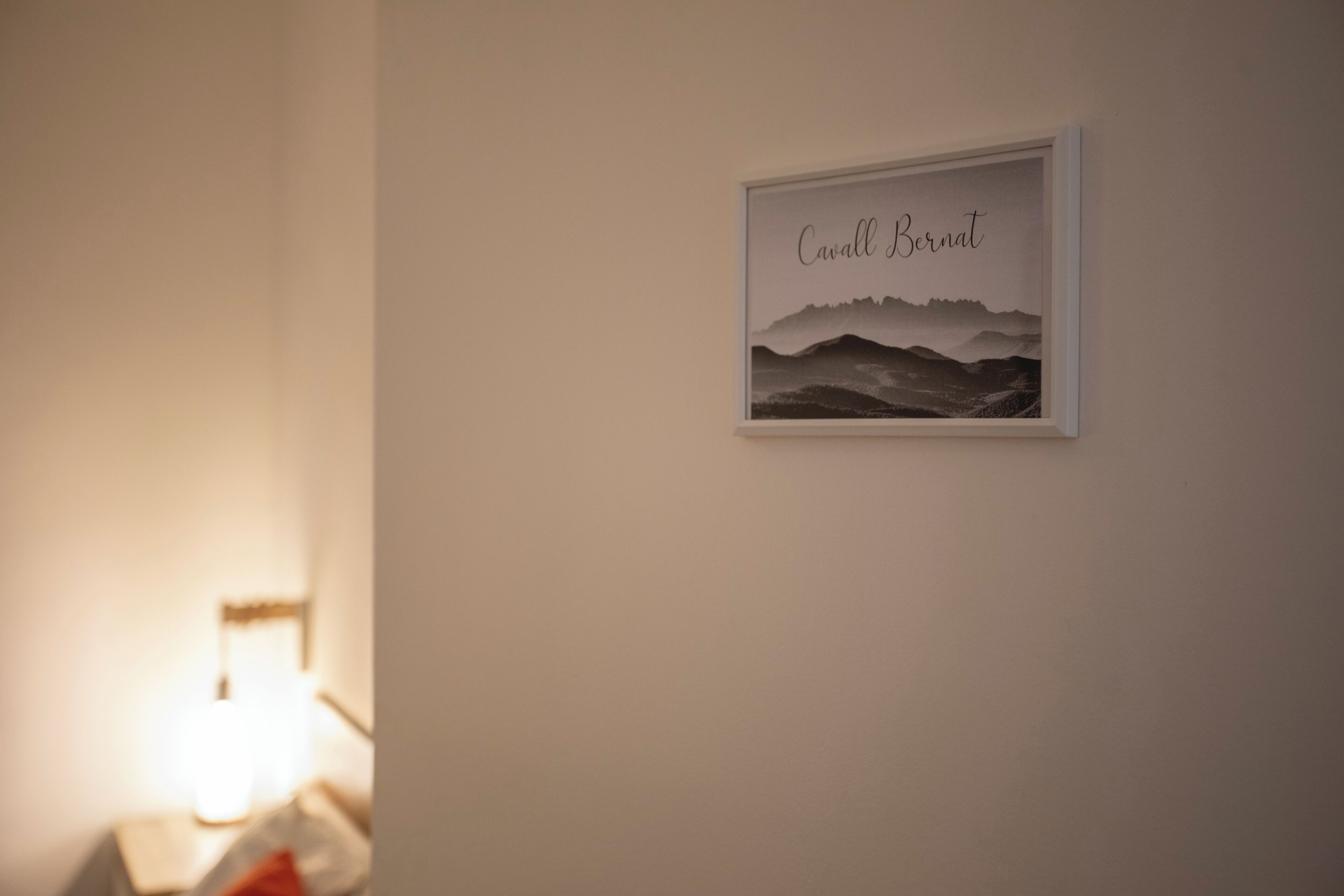 Un tableau encadré accroché au mur, portant le nom « Cavall Bernat » et représentant un paysage.