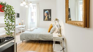 A modern bedroom with a bed, desk, and chair, a large mirror, and a painting on the wall. - Rome Lux House guest rooms (Rome)