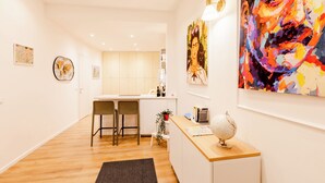 A modern kitchen with white cabinets, a wooden countertop, and two bar stools. - Rome Lux House guest rooms (Rome)