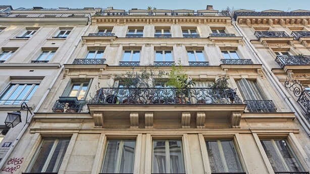 A multi-story building with a classical architectural style, featuring ornate balconies and large windows.