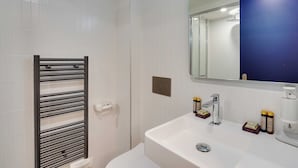 A bathroom with a white sink, a mirror, and a towel rack. - Comfortable Studio - 2P - Republique (Paris)
