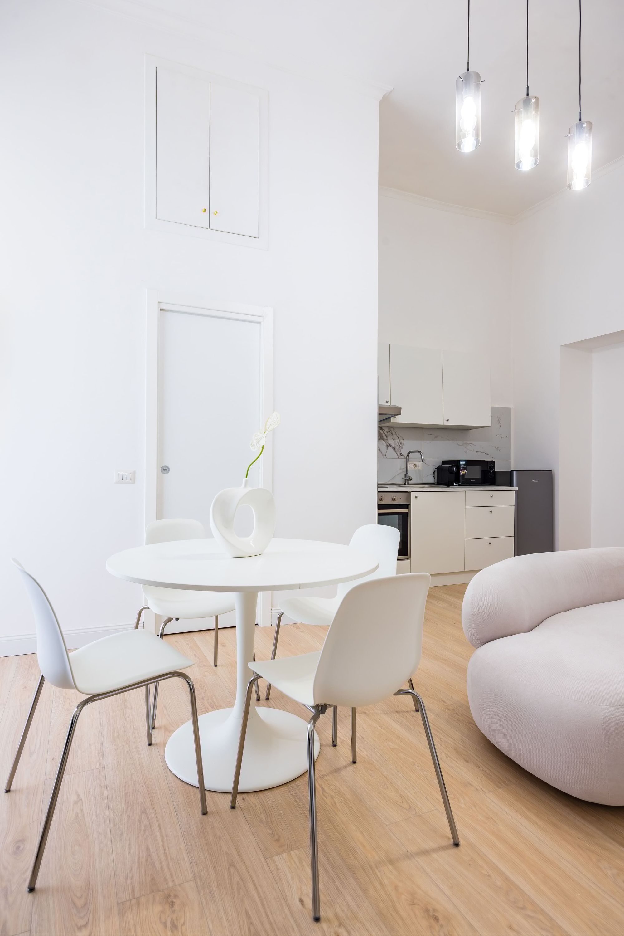A modern kitchen with white cabinets, a black microwave, and a grey refrigerator.