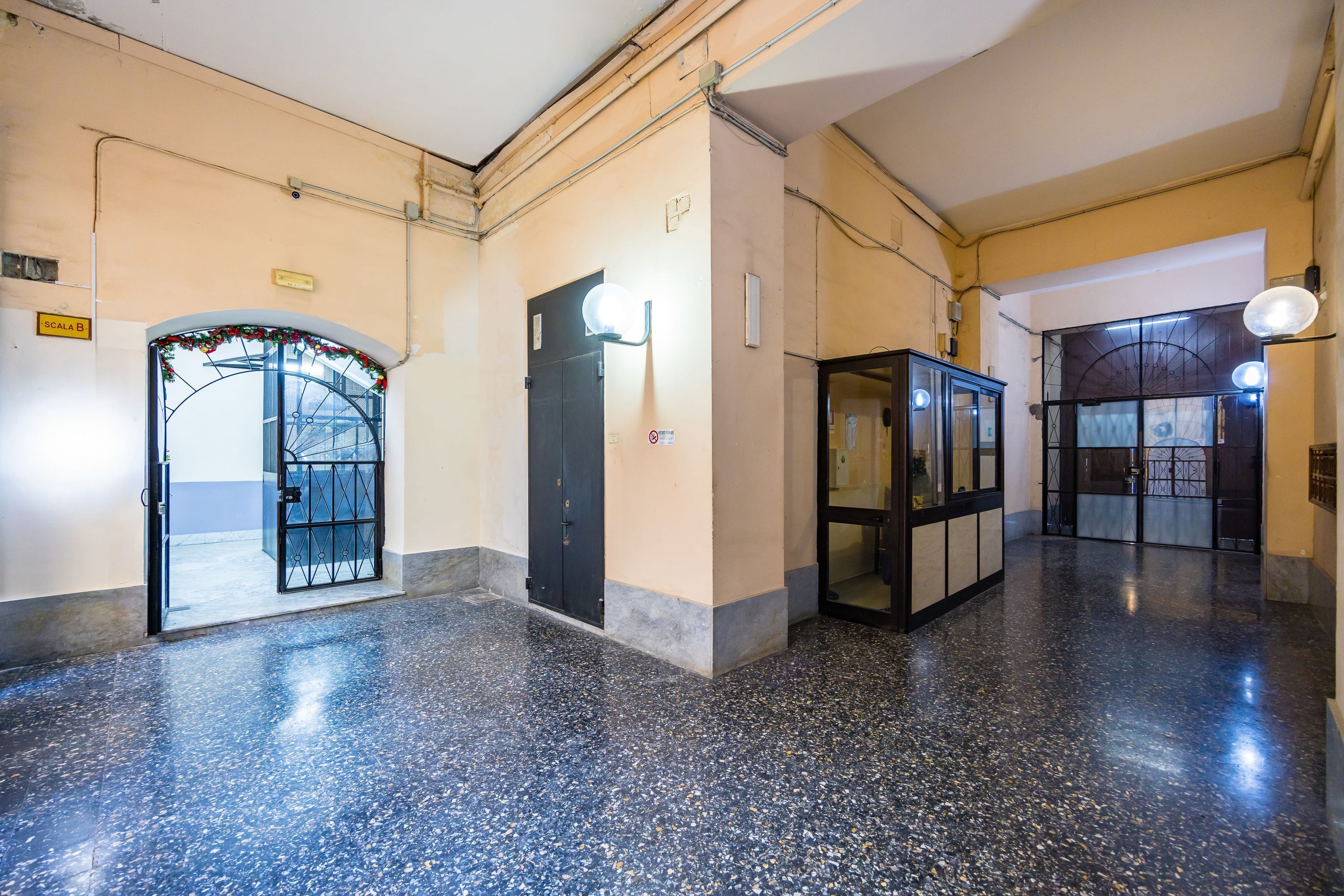 A spacious lobby with a polished floor, a reception desk, and a decorative archway.
