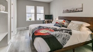 Un dormitorio con cama, escritorio, silla y ventana.