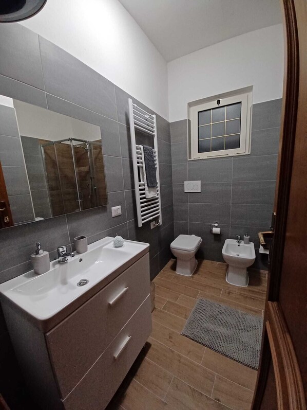 Un baño moderno con un espejo grande, dos lavabos, un inodoro y un bidé.