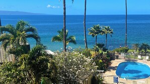 A pool area with a view of the ocean and palm trees. - Nestled Between Two Beaches Kihei Oceanview 2BR Condo Panoramic Views Pool (Kihei)