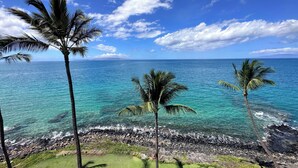 A tropical beach with clear turquoise waters, palm trees, and a rocky shoreline. - Nestled Between Two Beaches Kihei Oceanview 2BR Condo Panoramic Views Pool (Kihei)