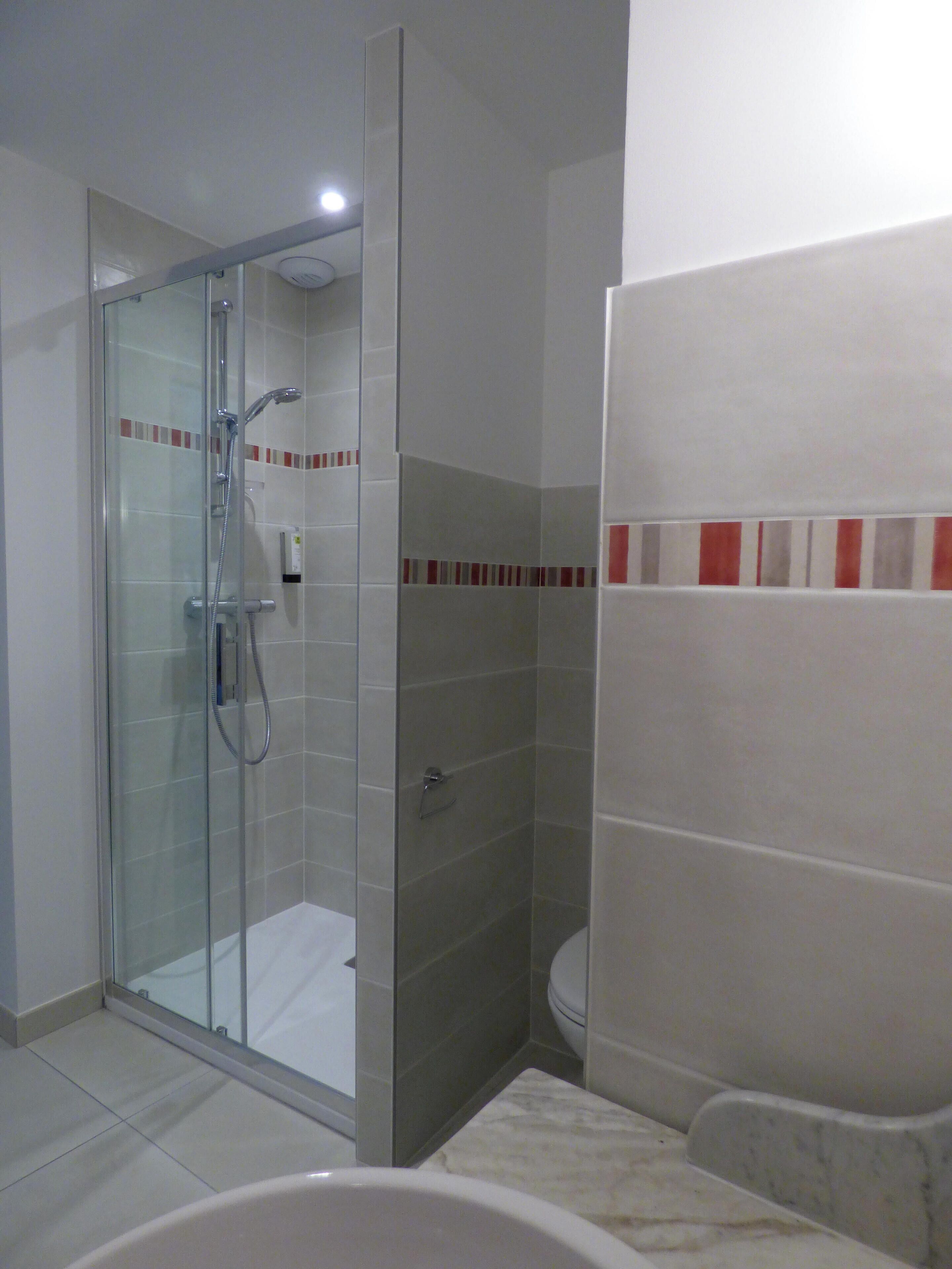 Un baño moderno con ducha de vidrio, inodoro y bañera.