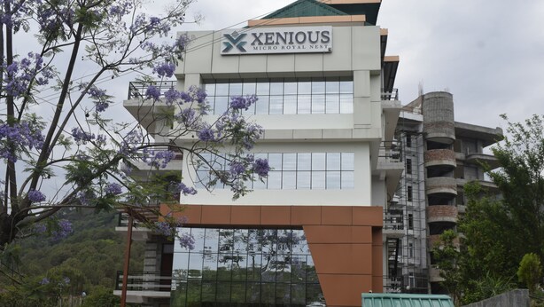 A modern building with a sign reading "Xenious Micro Royal Nest." - Xenious Micro Dharmshala  (Dharamshala)