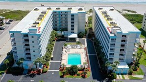 A hotel with a central pool, multiple floors, and a beach view. - Salt Life Escape: 2B/2B in Oceanfront Complex (Cocoa Beach)