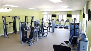 A gym with various exercise machines, treadmills, and a mirrored wall. - 4bed Home in Storey Lake With Private Pool (Kissimmee)