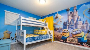 A child's bedroom with a bunk bed, Minion-themed decor, and a castle mural. - Amazing 5 Suite Home With Resort-style Amenities (Davenport)