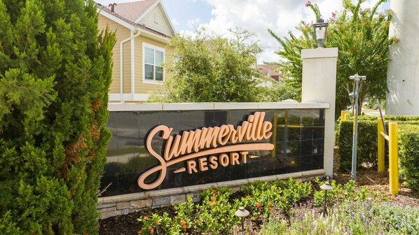 A sign for Summerville Resort with a black background and gold lettering.