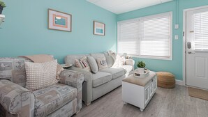 A living room with two sofas, a coffee table, and a door with white blinds. - Cozy 1BR condo North Wildwood with WiFi, AC, 1.5 blk to beach, Boardwalk, Moreys (North Wildwood)
