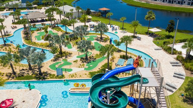 A water park with a large pool, multiple slides, and a golf course area. - Great Home Mickey Harry Potter Beds Top Spot (Kissimmee)