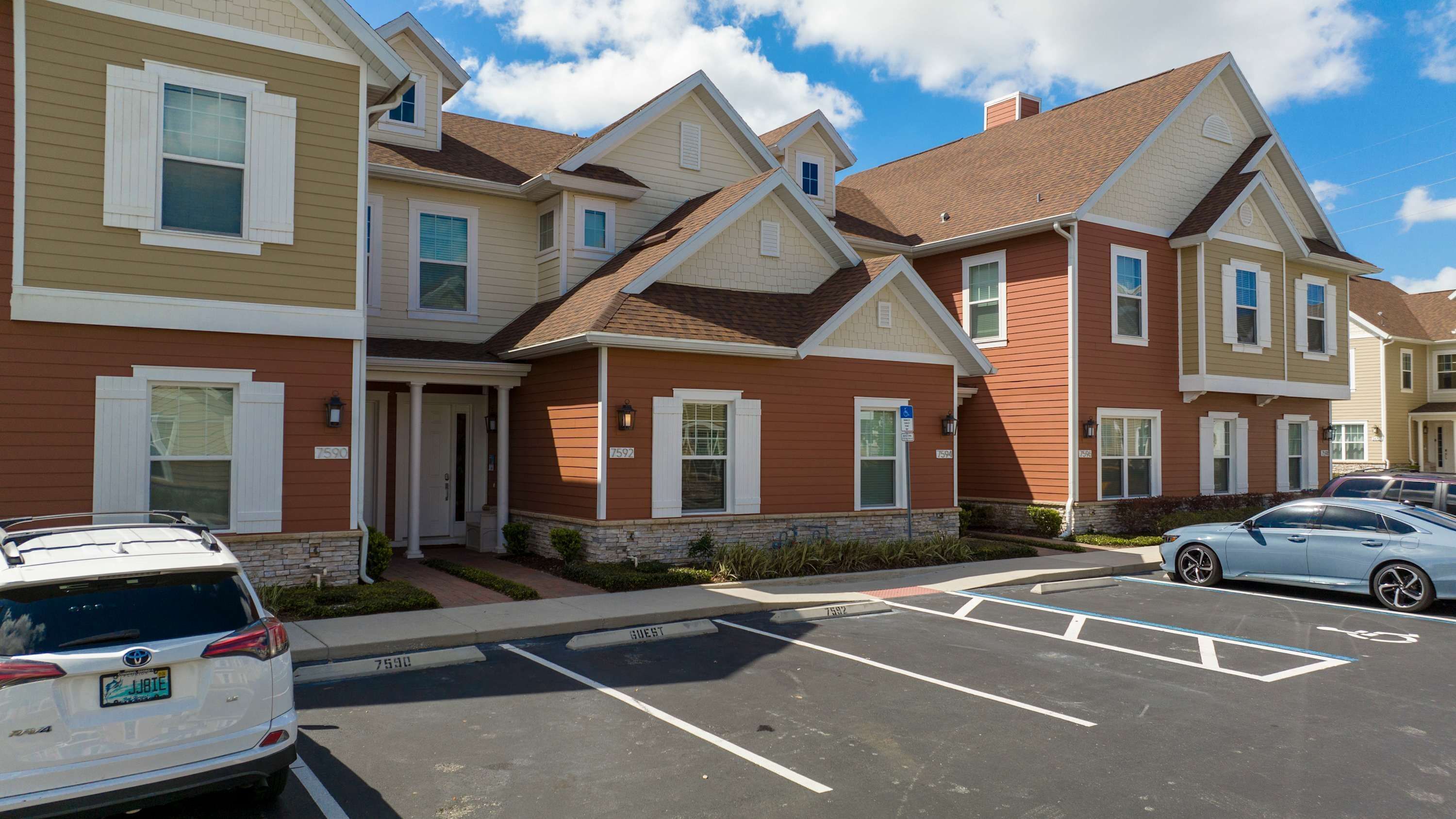 A row of townhouses with a parking lot in front.