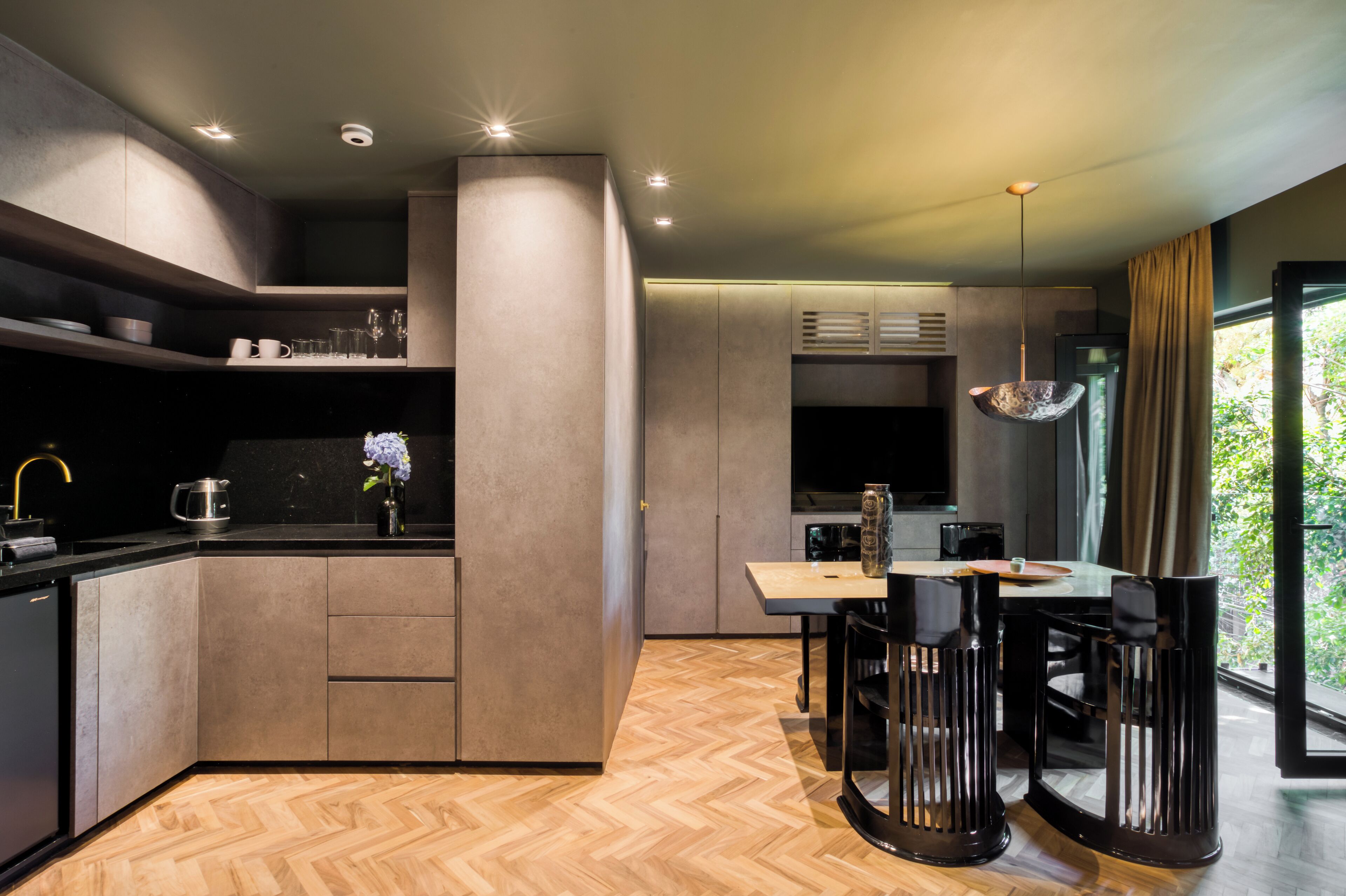 A modern kitchen with a central island, built-in appliances, and a dining area with a wooden table and chairs.