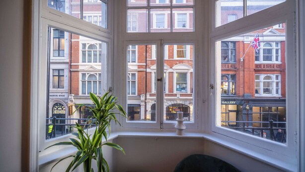 A corner room with a bay window overlooking a city street.