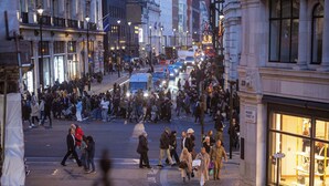 A busy urban street scene with pedestrians and vehicles.