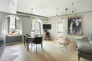 A modern living room with a dining area, a sofa, and a TV. - Superbe Apartment Saint Germain des Pres (Paris)