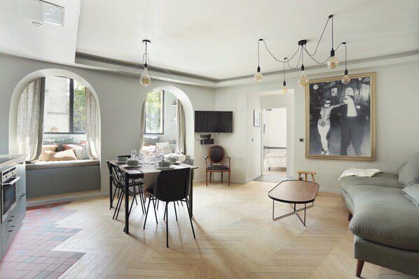 A modern living room with a dining area, a sofa, and a TV. - Superbe Apartment Saint Germain des Pres (Paris)