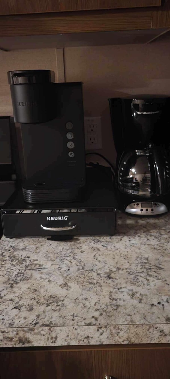 Et køkken med en Keurig kaffemaskine på en granitbordplade.