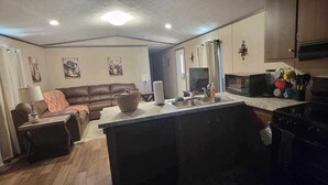 A compact living space with a kitchenette, a sofa, a coffee table, and a dining area. - Your Peaceful Georgetown Escape (Georgetown)