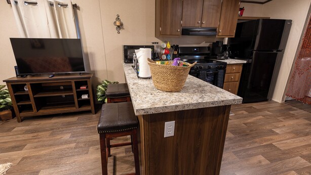 A kitchen with wooden cabinets, a granite countertop, and a center island with stools. - Your Peaceful Georgetown Escape (Georgetown)